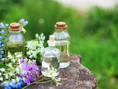 Essential aroma oil  in bottles on wooden background outdoor. Selective focus. Natural ogranic products.